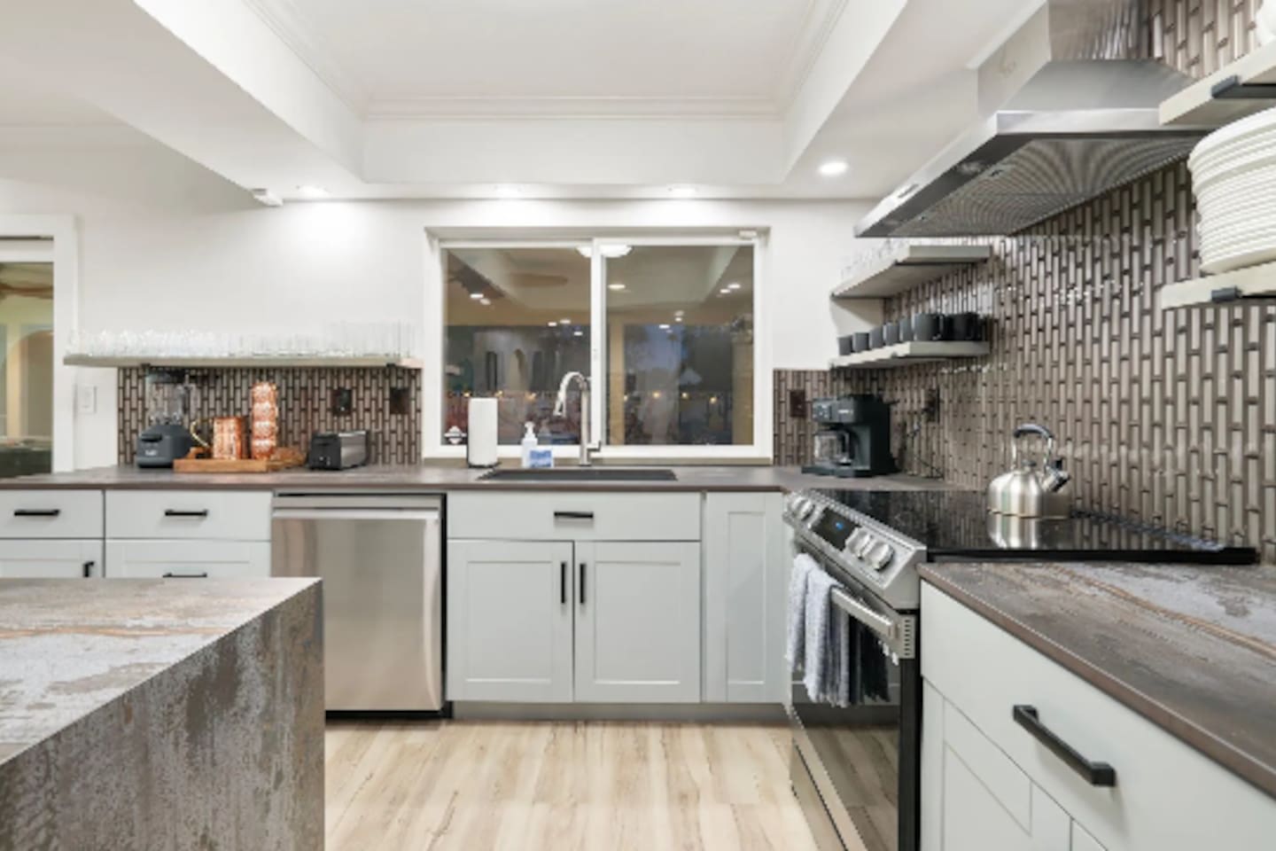 Textured tile backsplash and stainless appliances bring a modern edge to this fully equipped kitchen.