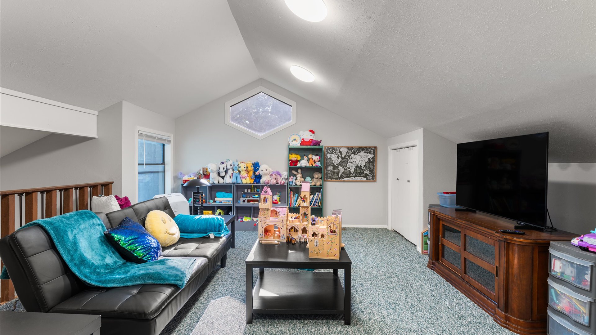 Children’s Loft features a 65" TV, toys for ages 2-8, including Barbies, trucks, books, and games. A fold-out couch can fit a small adult, with fresh linens, blankets, and pillows provided.