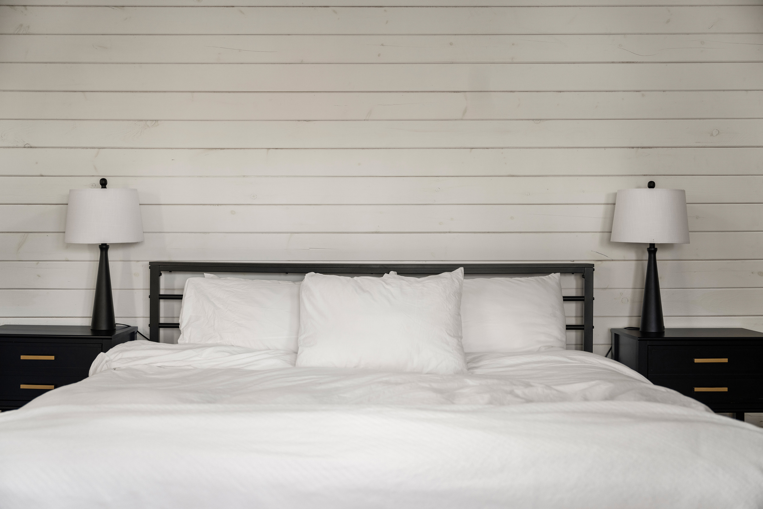 Bedroom 1: Sunlit space with sleek decor, inviting bedding, and modern lamps for a restful stay!