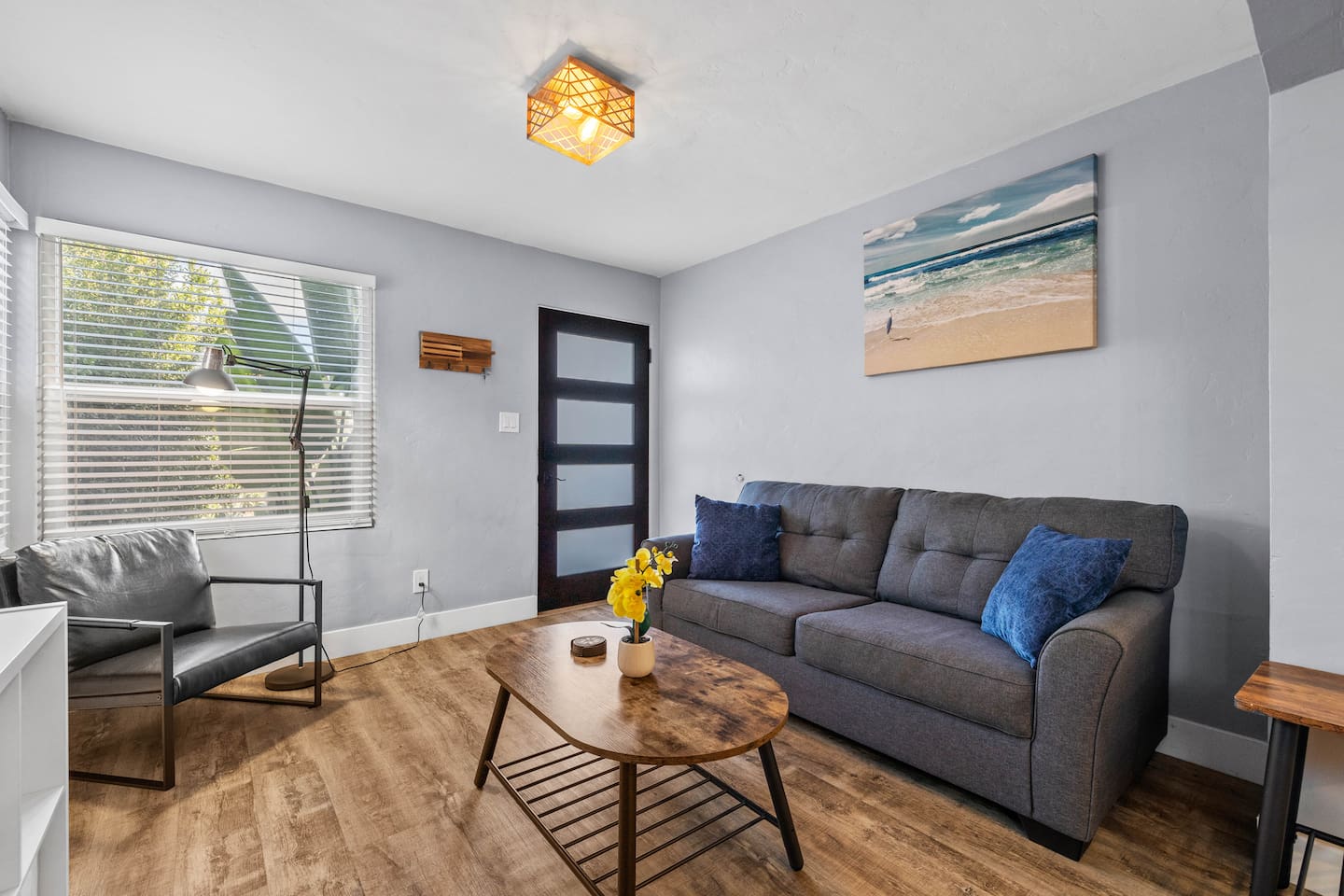 Unwind in a stunning living room adorned with a lovely painting, comfortable sofa, and chic coffee table. Enjoy movie nights with the TV and the cozy glow from a stylish chair, perfect for your getaway!