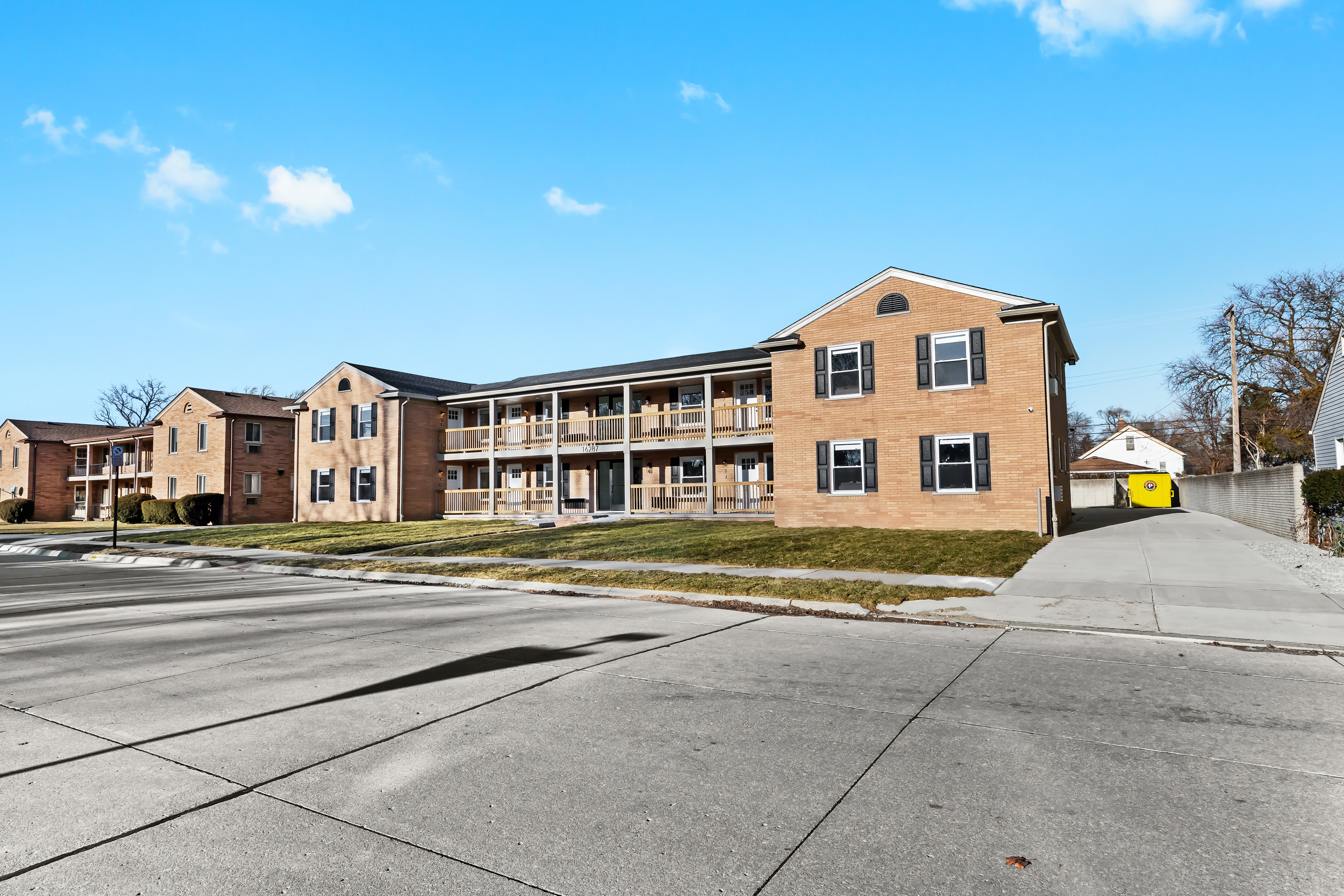 Charming brick apartment building with a welcoming entrance, private balconies, and a peaceful setting—offering a comfortable and convenient place to stay.