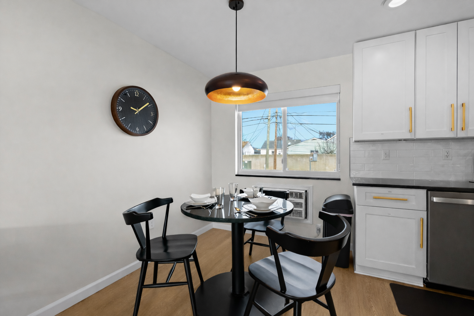 Modern dining nook with stylish seating, warm pendant lighting, and a bright window—perfect for enjoying meals or morning coffee.