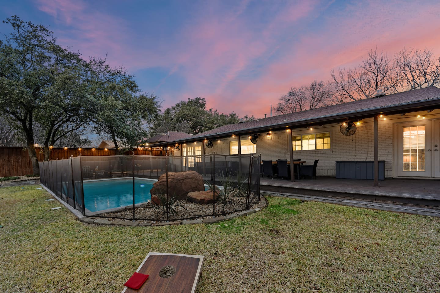Kick back in this spacious, fully-fenced backyard and make memories during your stay: sparkling pool with a waterfall and a fence for children, ample string lights throughout, fans on the patio, a firepit, patio/dining furniture, pool toys, + more!