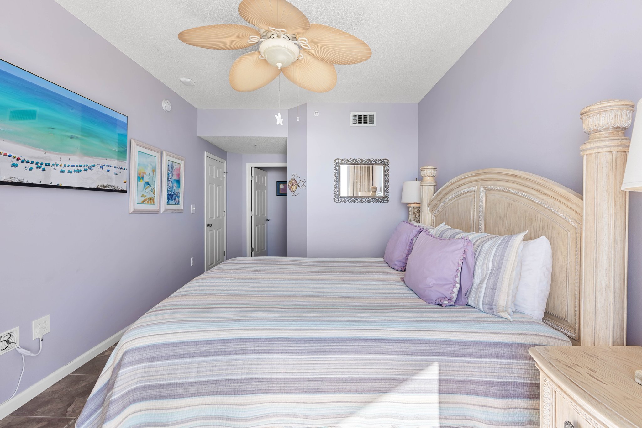 Primary bedroom w/ cozy bed setup & a relaxed, beachy atmosphere.