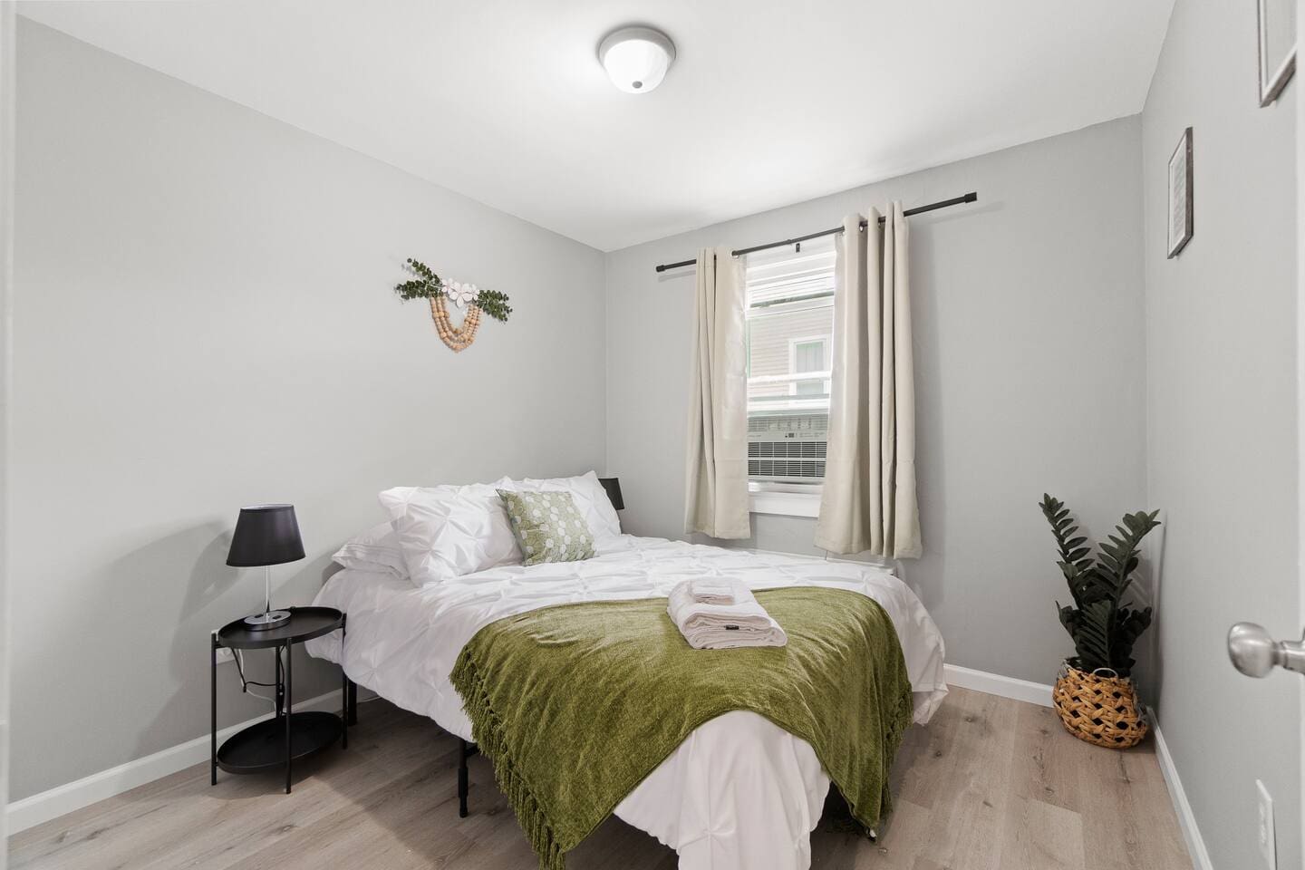 Charming queen-sized bedroom with a cozy bed and a window, letting in plenty of natural light for a restful atmosphere.