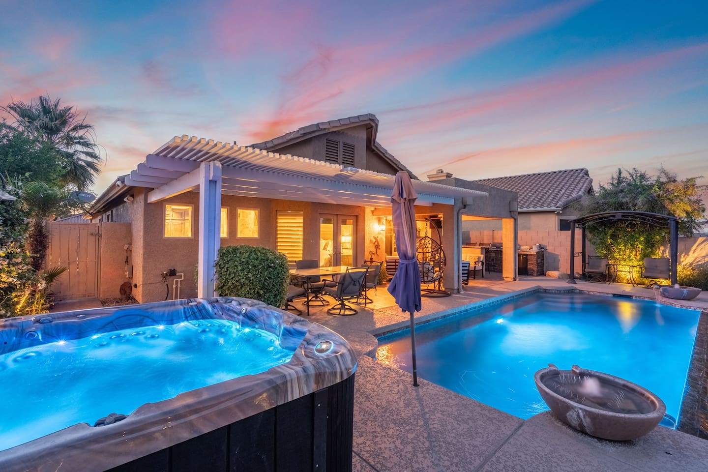 As the Arizona sky turns pink and gold, the pool glows and the hot tub beckons — evenings at this backyard are simply unforgettable.