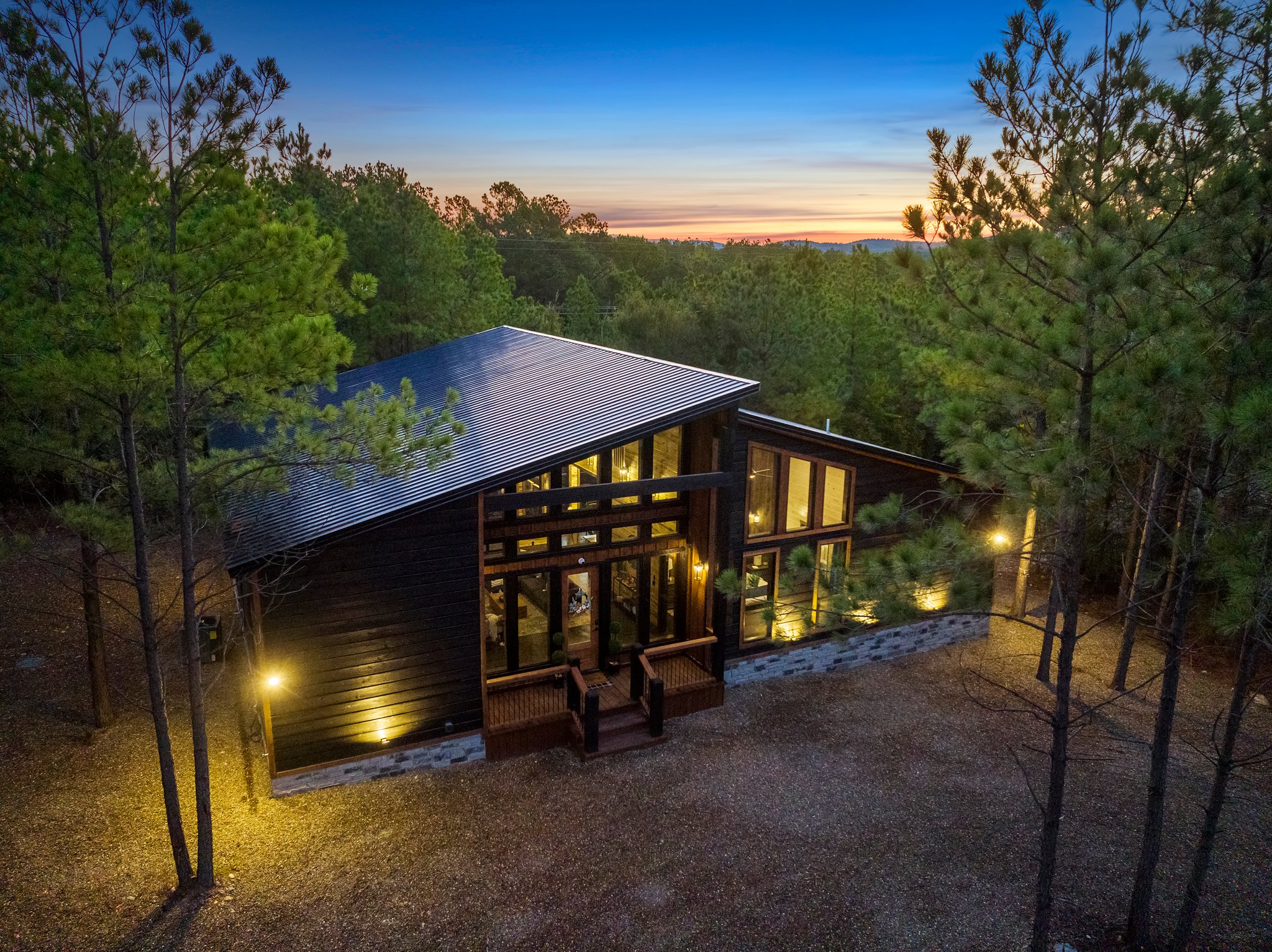 Enjoy peaceful seclusion in this beautifully designed woodland getaway with expansive windows and cozy lighting.