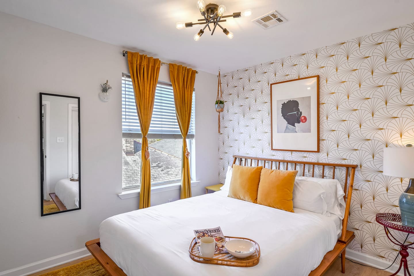 The 'Gold Room' has luxe queen bedding, chic decor, and abundant natural light for a cozy stay 