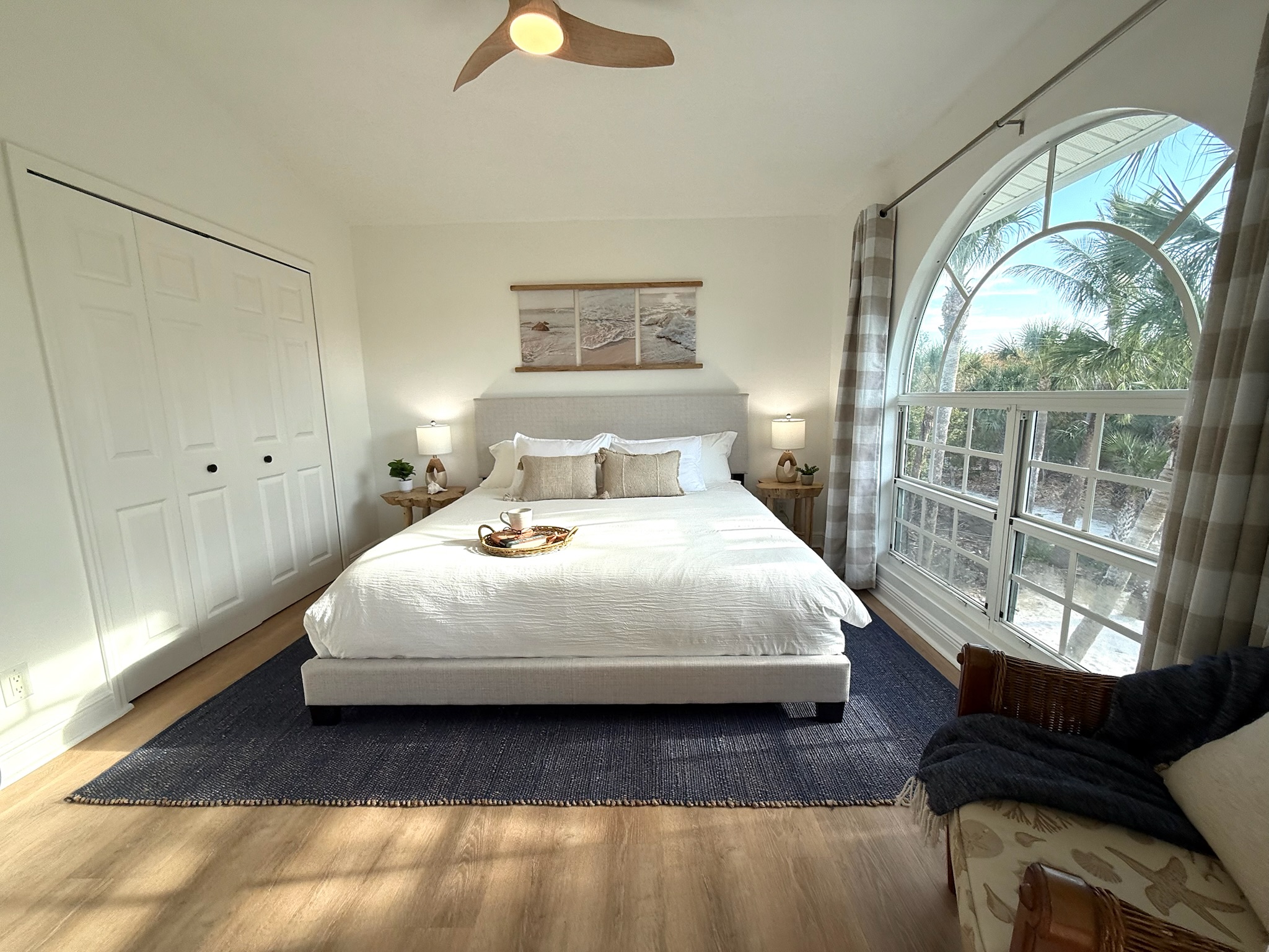 King size bed and an oversized window with lush palm-lined views of the property