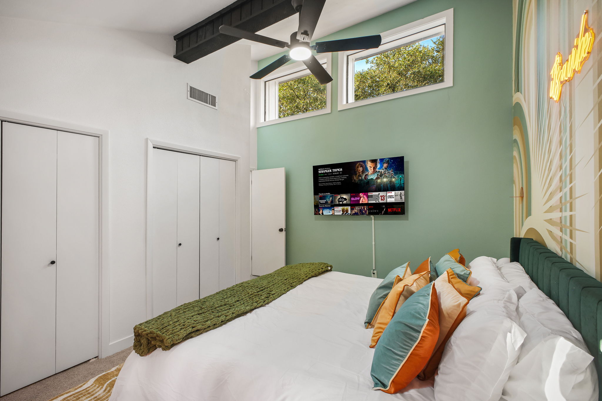 Bedroom 4: Spacious king bedroom with Smart TV, soaring ceilings, and vibrant natural light.