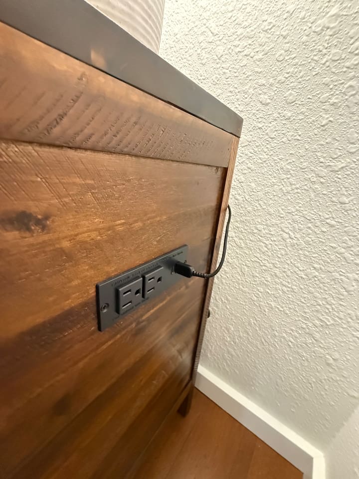 Nightstands with electrical outlets and USB outlets on either side of the bed. 