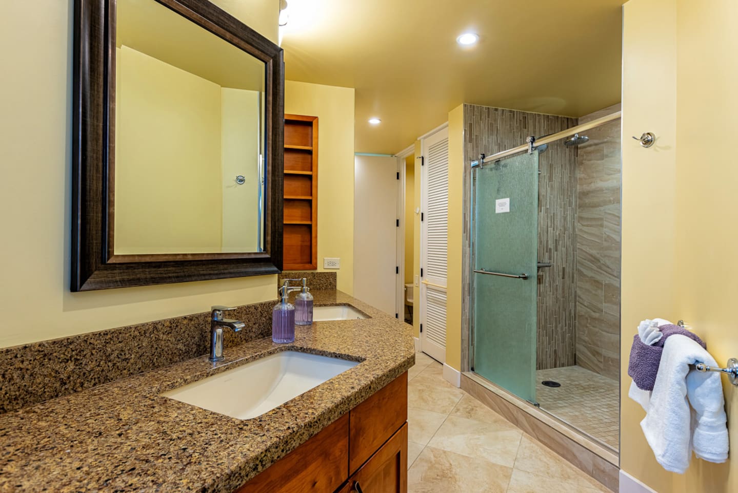 the master bathroom features a double vanity, oversized walk-in shower with bench and rain showerhead, and a full-size washer/dryer