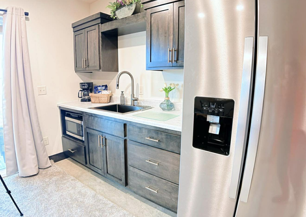 View of kitchenette with full sized fridge. Just no oven is all.