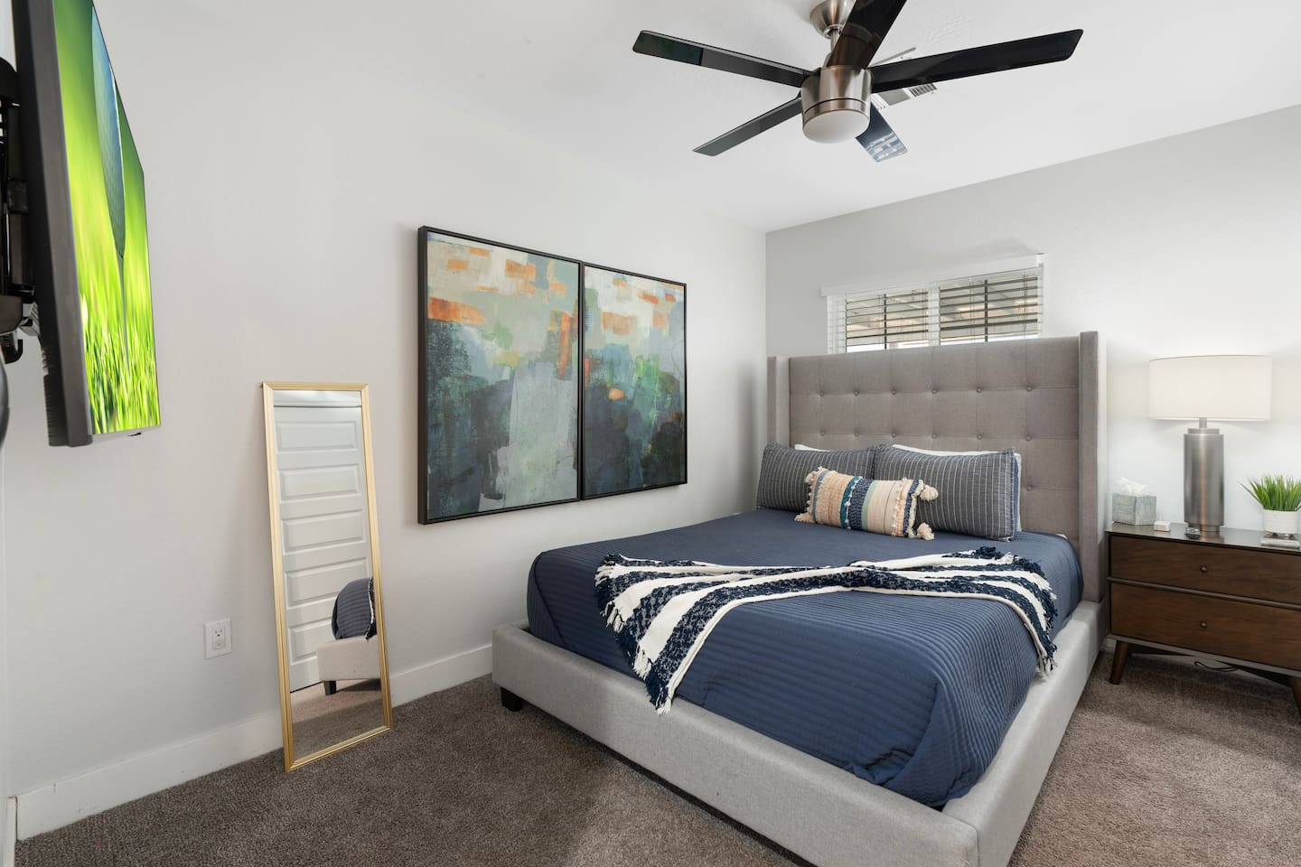 Spacious bedroom with a sleek mirror, enhancing the room's sense of openness and style.