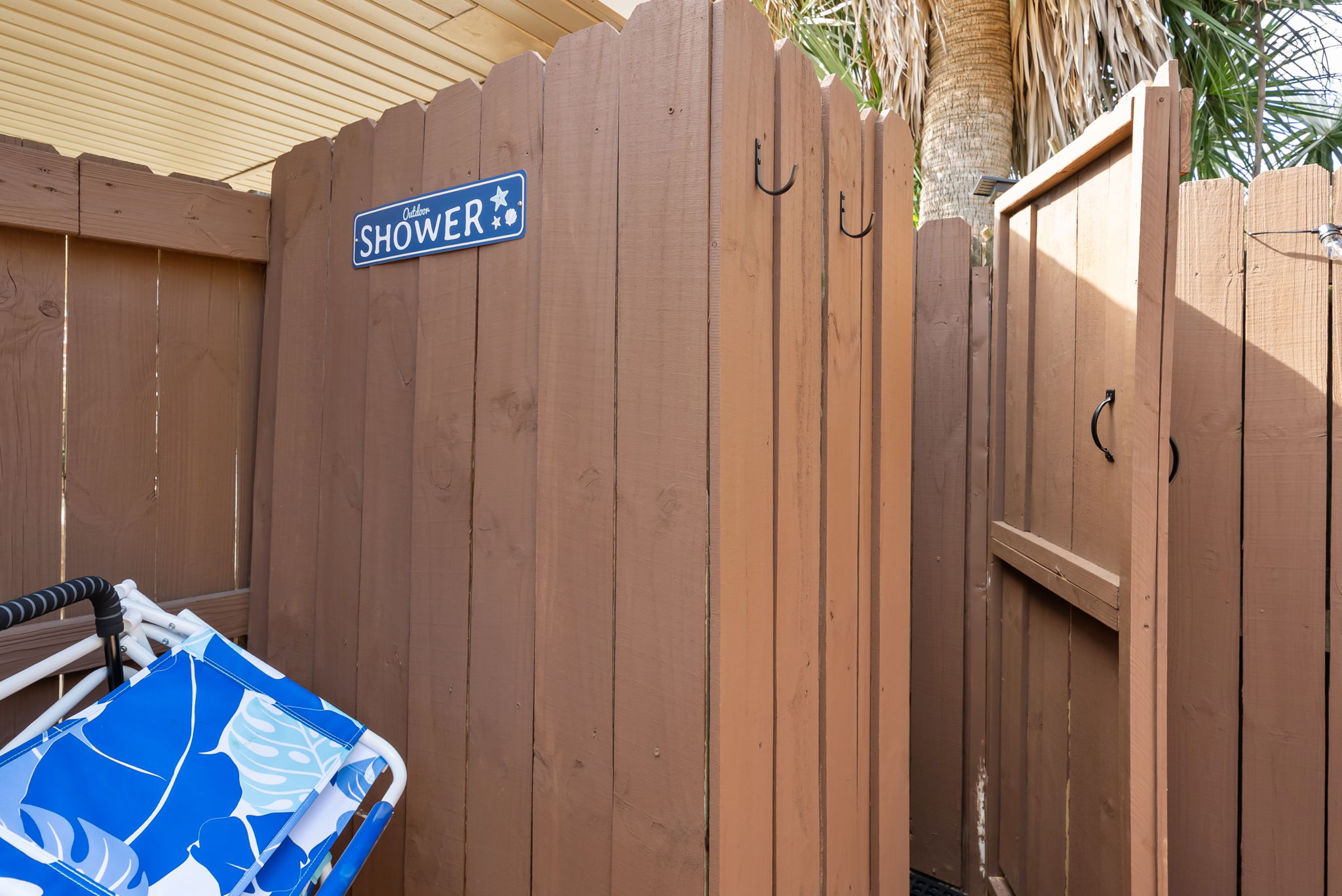 Rinse off the sand right here. The outdoor shower with its
beach-blue signage sits just off the deck, so the Gulf stays outside
where it belongs.