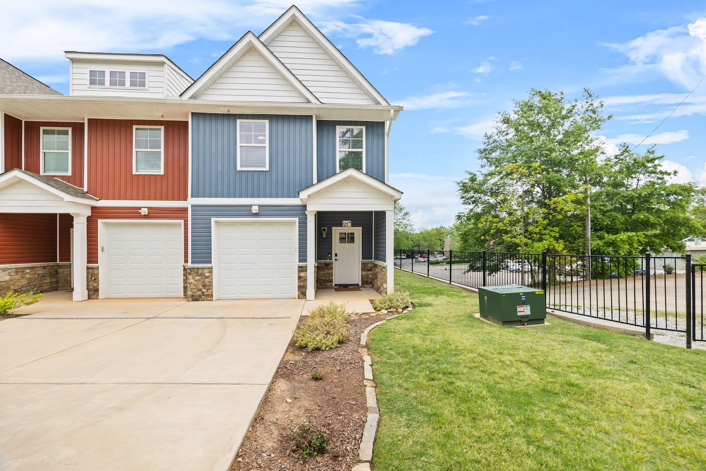 Ample driveway parking and a peaceful setting make this blue townhome both functional and photogenic.