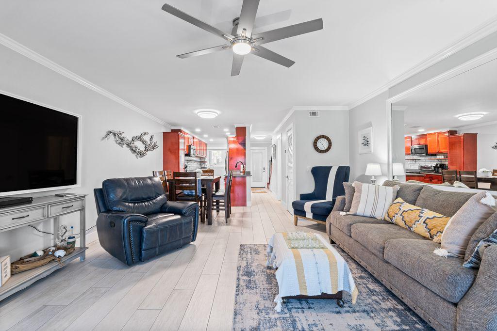 Spacious living area with fireplace, ceiling fan and smart TV