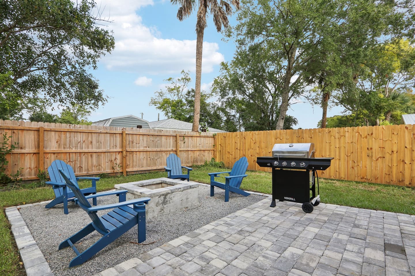 Outdoor firepit with 4 Adirondack chairs, BBQ grill, and outdoor picnic table