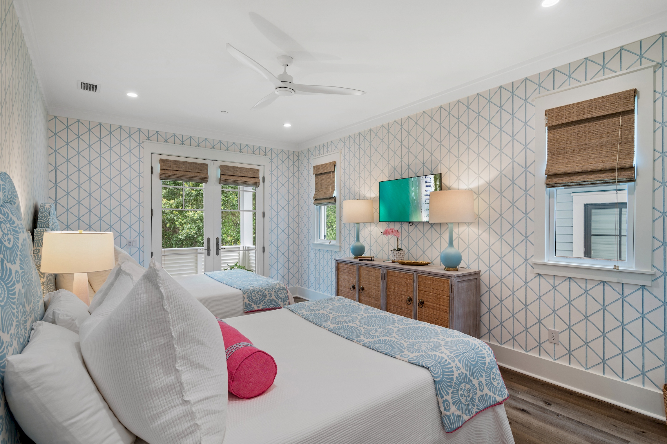 Wall mounted TV and french doors to the deep balcony.