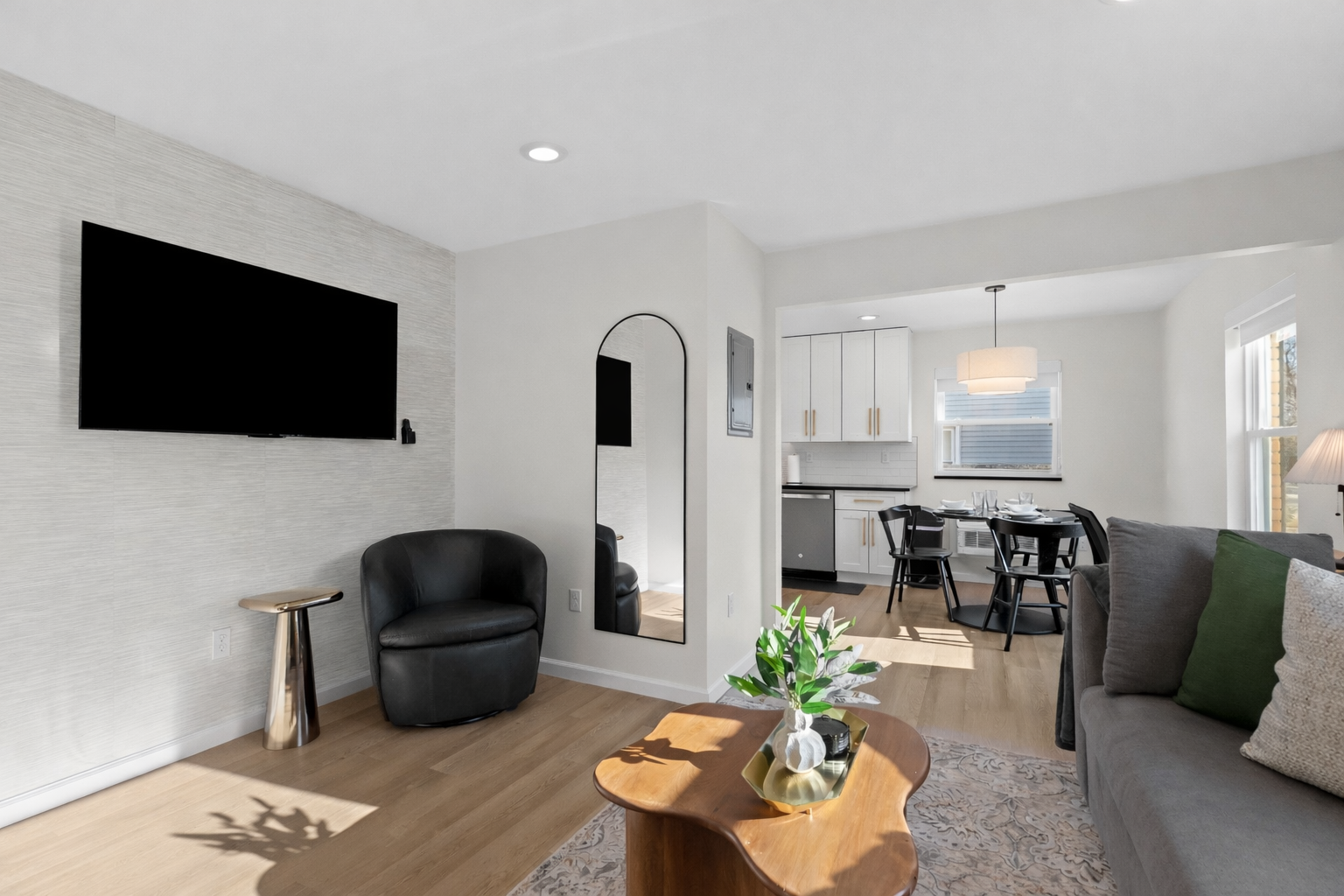 Relax in this bright, open living area featuring a smart TV, stylish seating, and seamless flow into the dining and kitchen spaces.