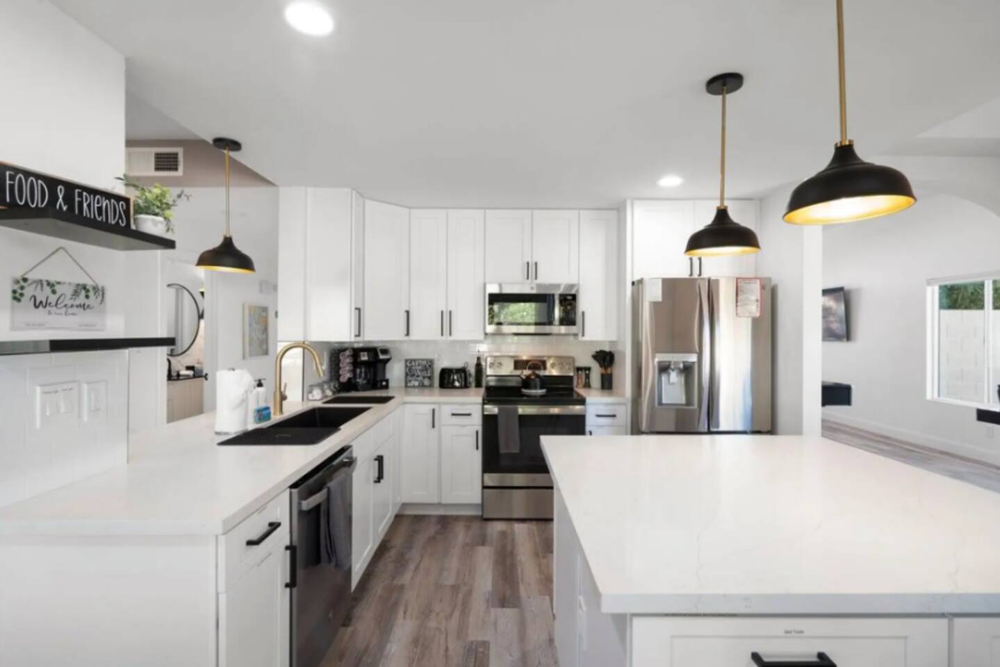 Bright, airy kitchen with island, stainless steel appliances, and abundant counter space.