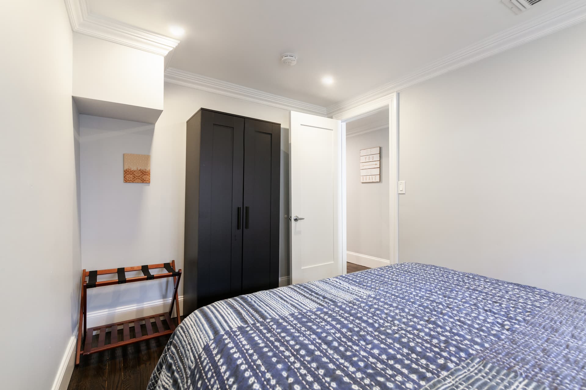 Second bedroom (view of dresser) and luggage holder. 