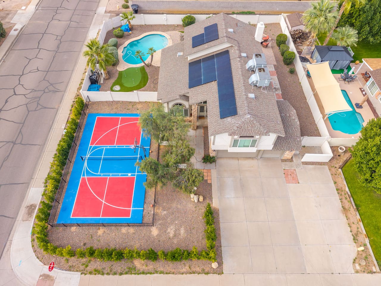 Aerial view of resort compound featuring sports court, multiple pools, solar power, and extensive outdoor entertaining spaces.