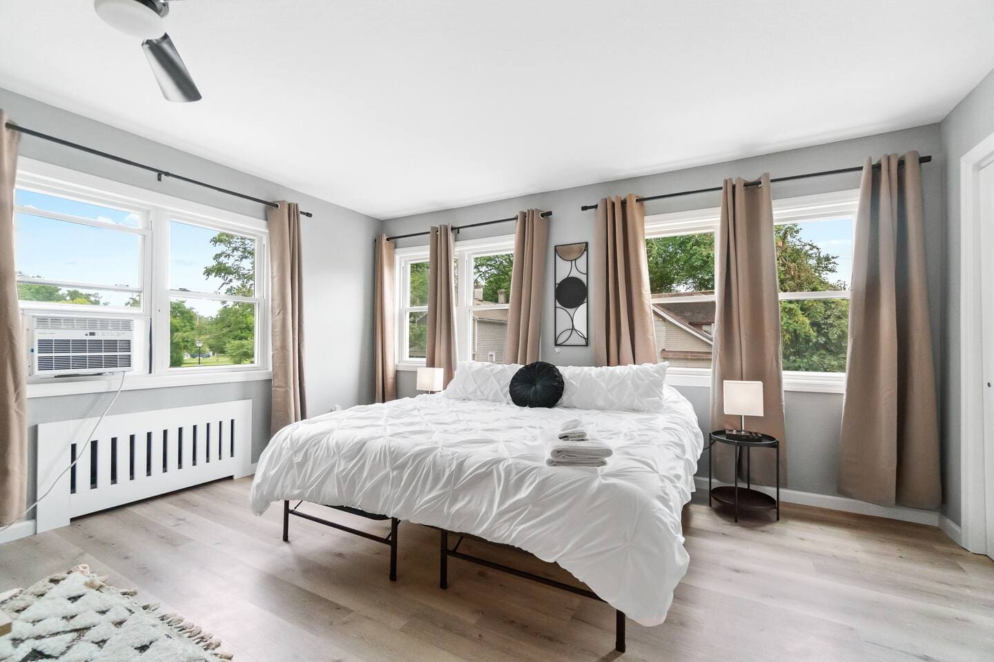 Cozy bedroom with large windows, filling the space with natural light and a calming atmosphere.