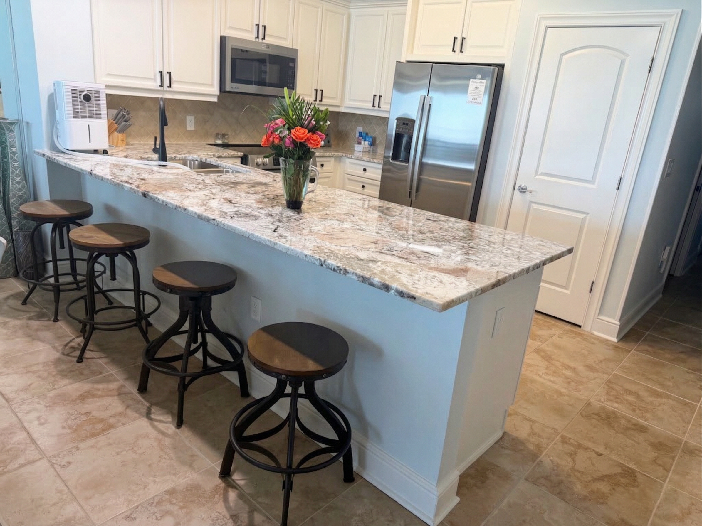 Spacious kitchen with granite countertops, stainless appliances, and bar seating—perfect for coffee mornings or family meals together.