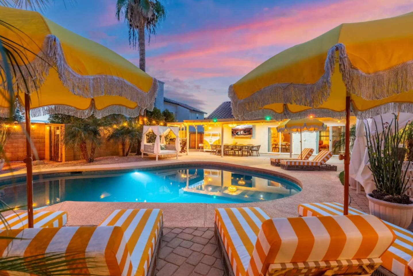 A cozy umbrella nook with lounge chairs offers a quiet corner beside the pool.