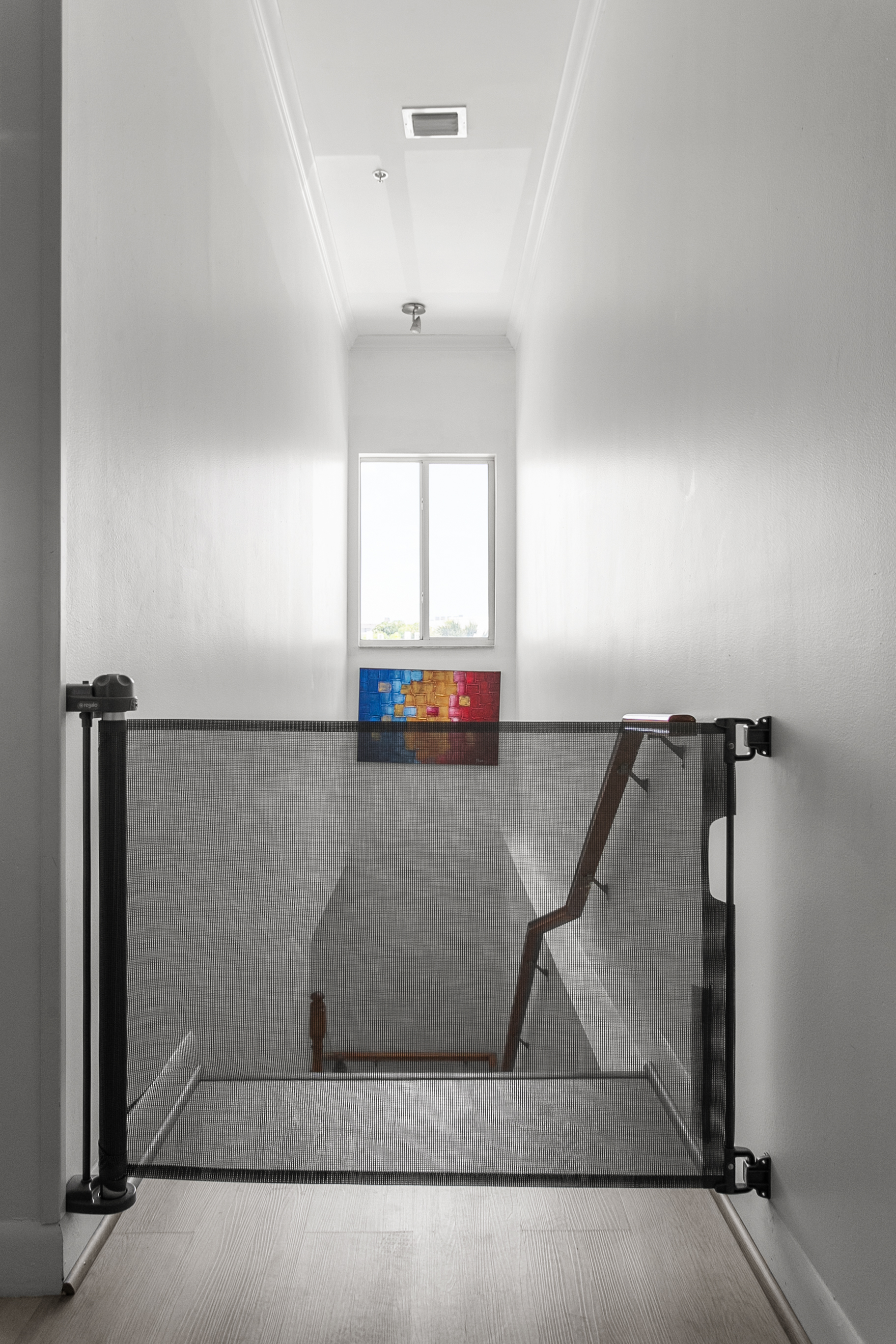 Retractable child gate at staircase landing