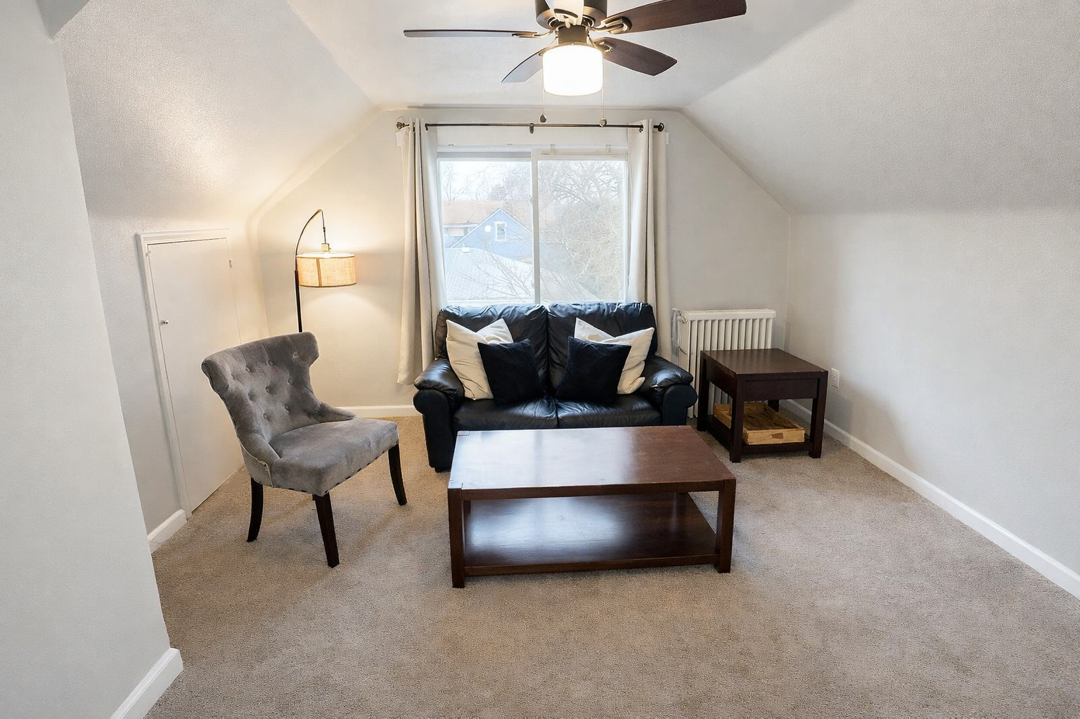 The inviting living room boasts ample seating options and additional air conditioning for extra comfort during the summer months