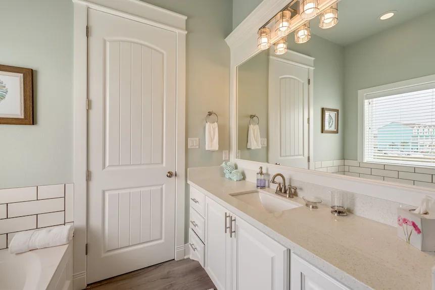 Breezy Point Bathroom 1: Ensuite featuring a toilet, bathtub, and separate shower, conveniently connected to the primary bedroom.