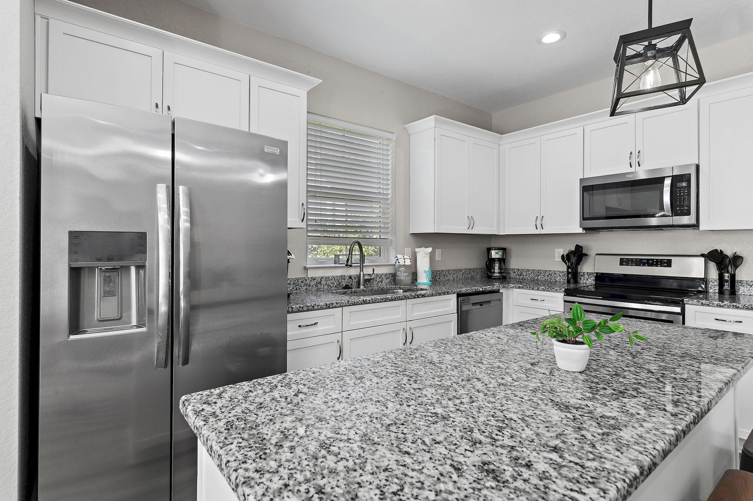 The kitchen is equipped with a large two-door refrigerator with ice maker, stove, oven, coffee-maker and dishwasher.