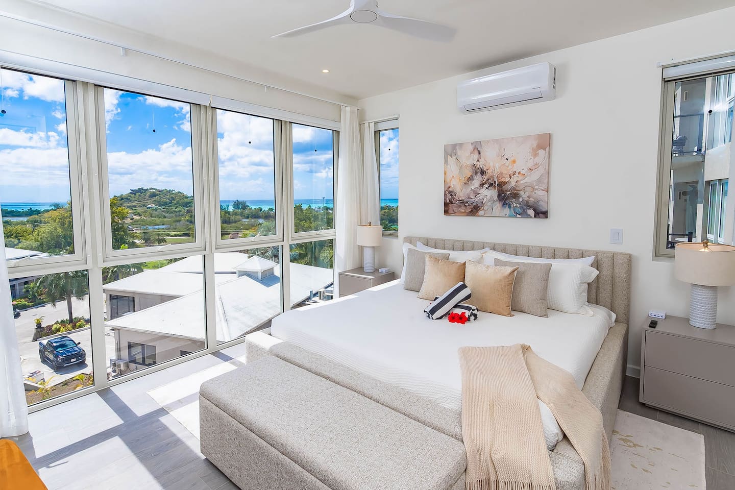 Master bedroom with king size bed, en-suite bathroom, air conditioning, ceiling fan, wall mounted tv, closet and gorgeous views of the ocean and hillside.