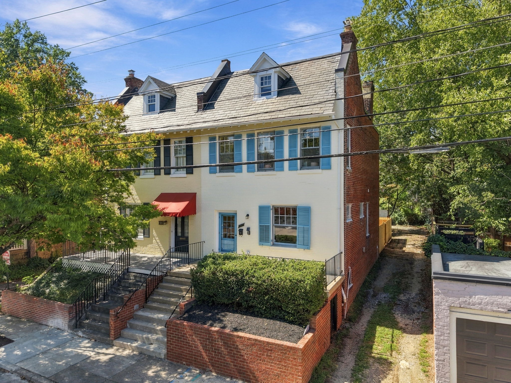 Exterior: Charming brick façade with vibrant blue shutters and inviting entryway awaits you!