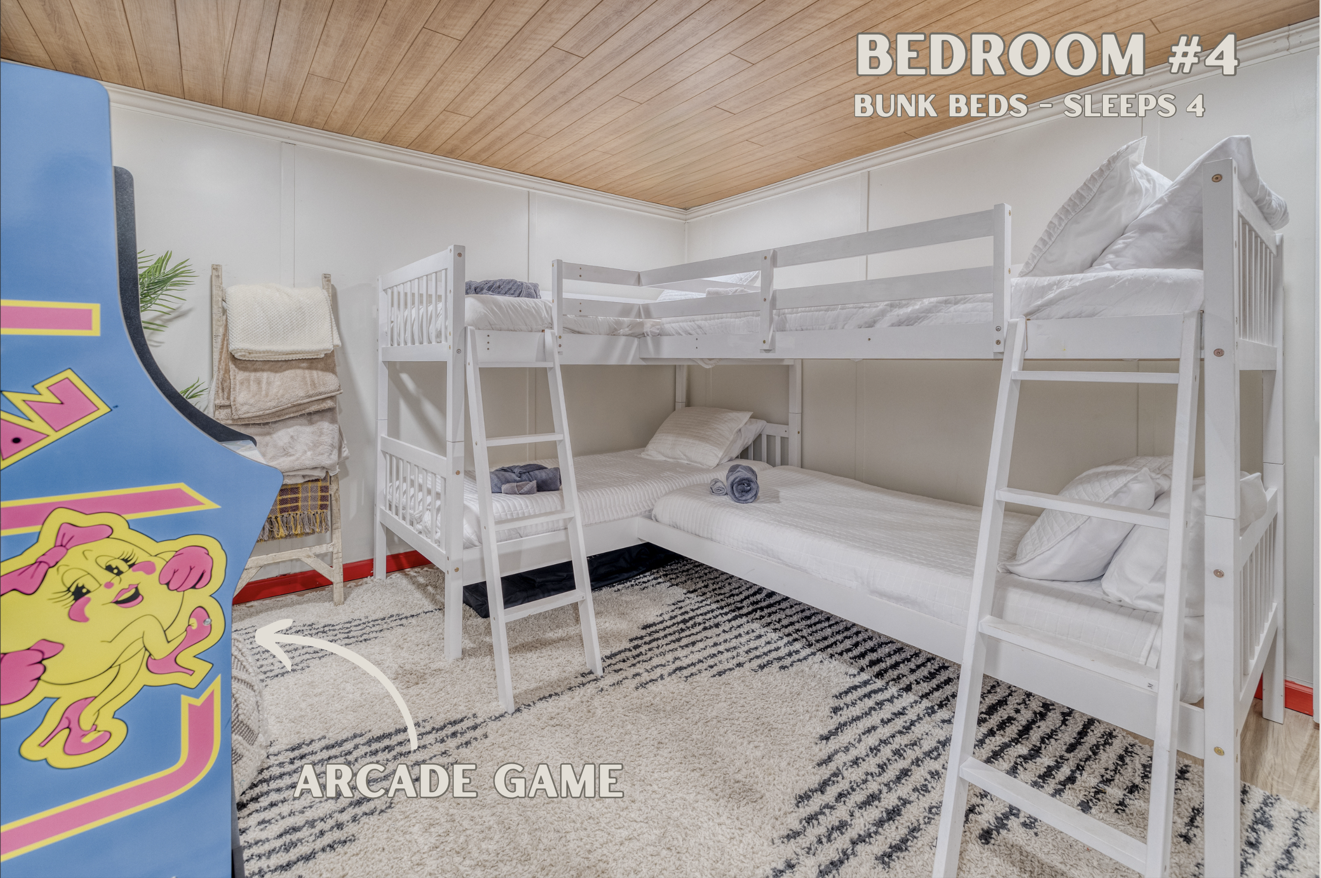This spacious bedroom features two sets of bunk beds and an arcade game, perfect for kids or teens to enjoy endless entertainment.