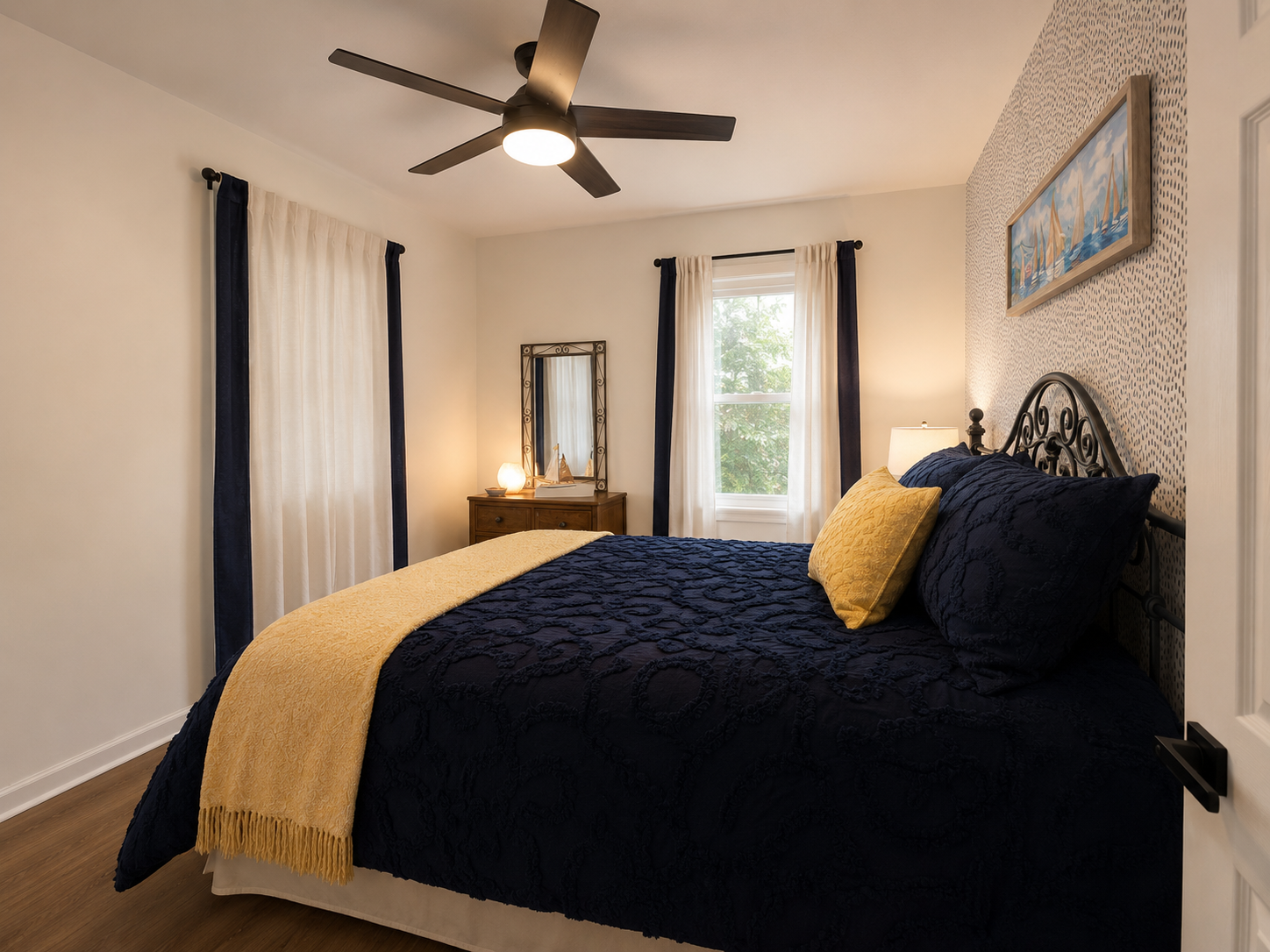 Cozy main-floor bedroom with a queen bed, soft natural light and easy access to the nearby hallway bath.