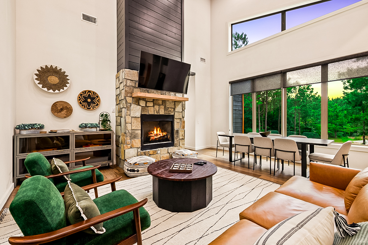 Cozy up by the fireplace in this stylish living room, complete with breathtaking views of the outdoors