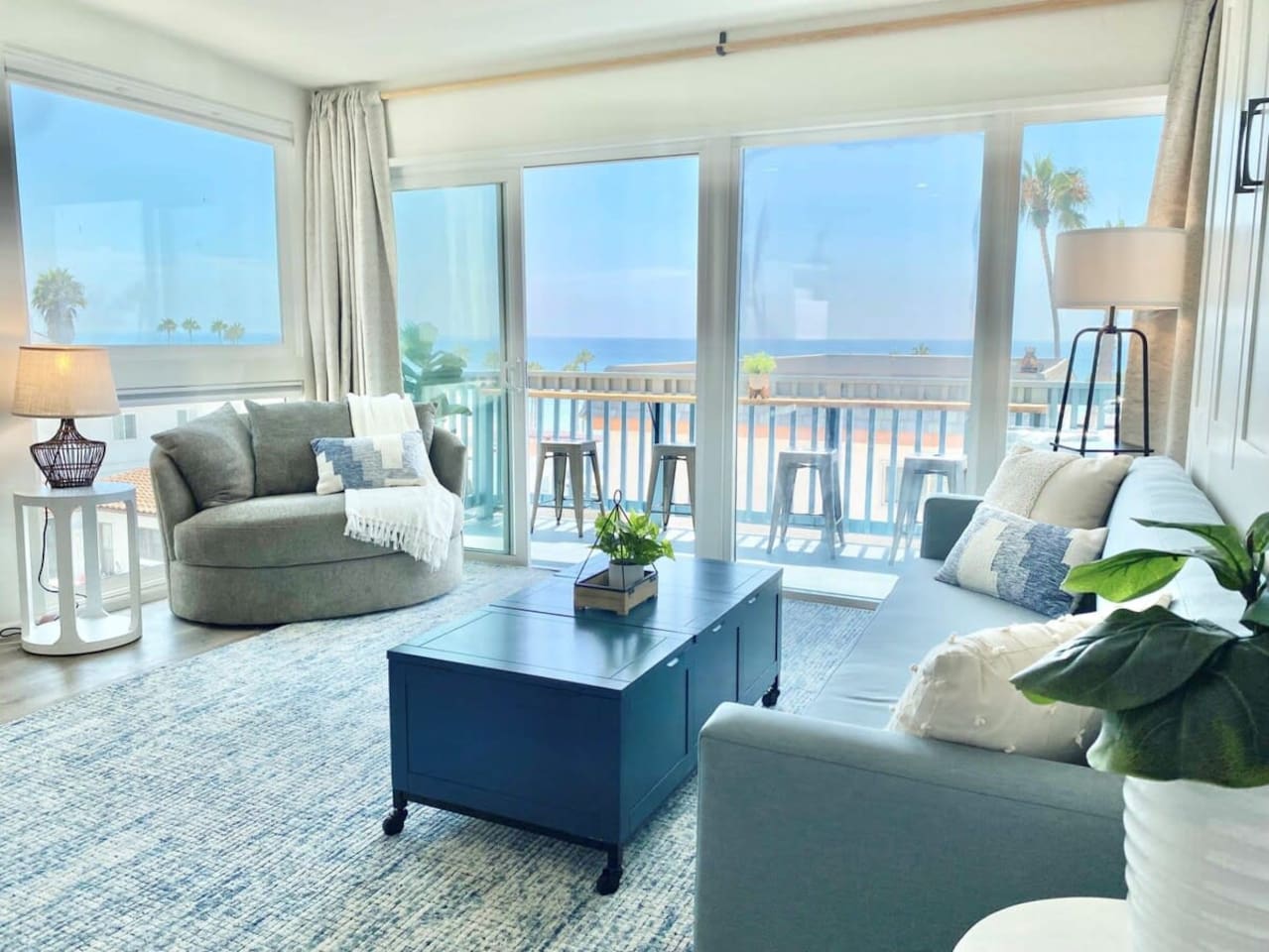 The living room has lots of comfortable seating, views and natural light pouring in from the balcony.