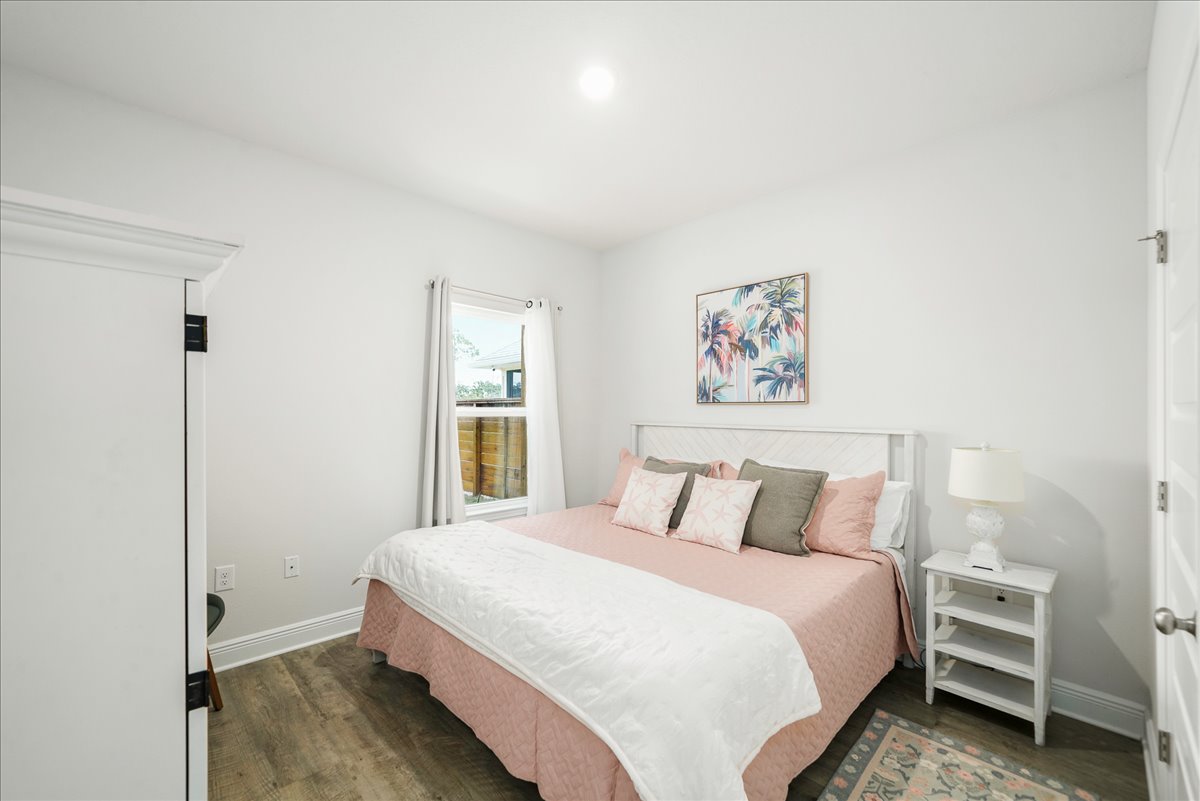 King Suite 2 downstairs includes a king bed with soft linens, Smart TV, closet, chair, and convenient luggage stand.
