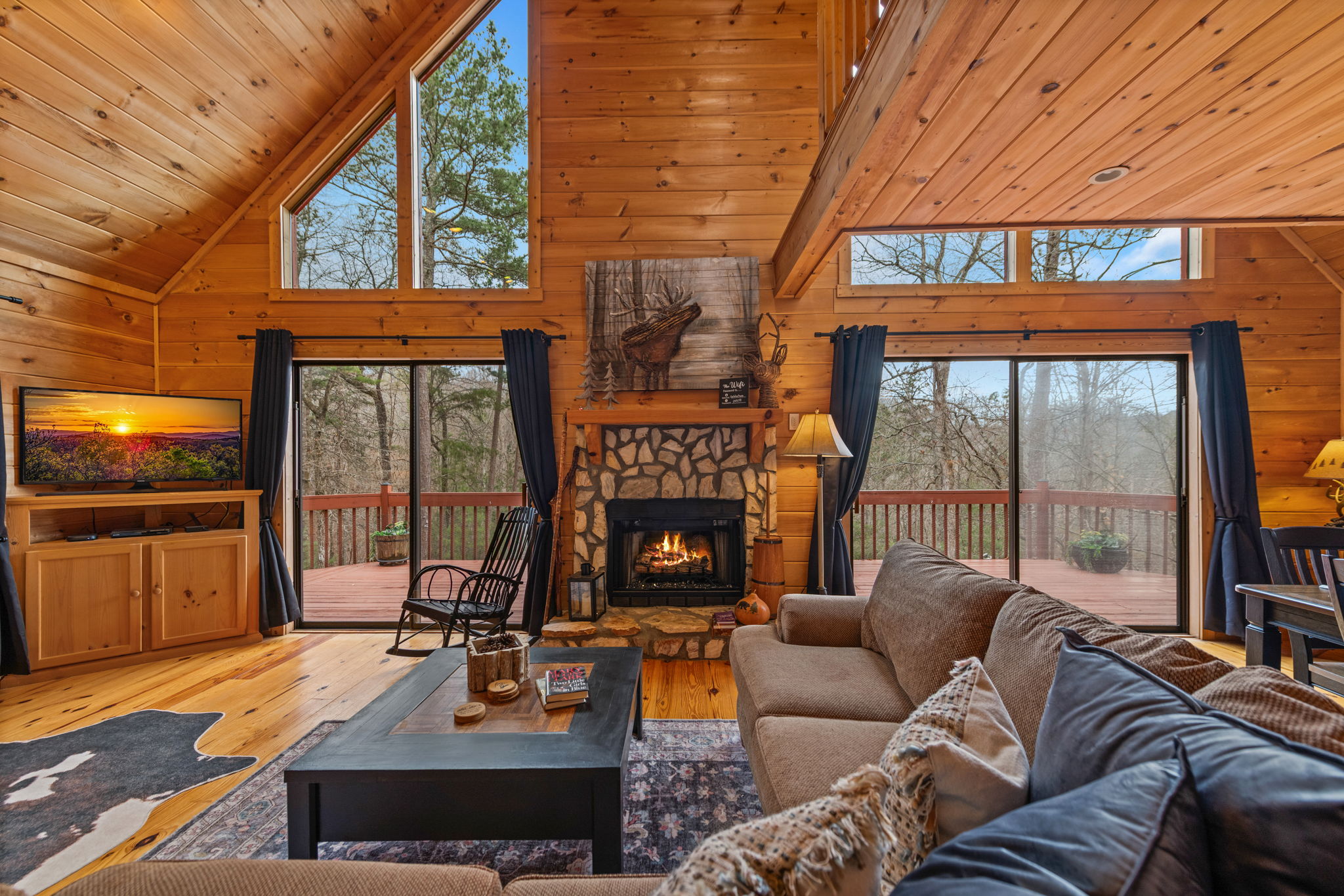 Large windows fill the room with natural light and showcase beautiful views of the outdoors.