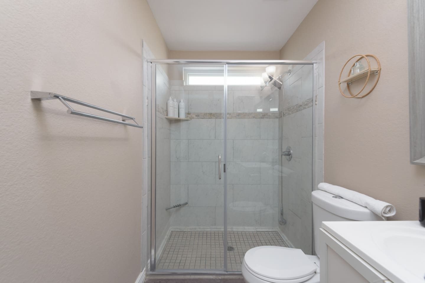 Guest bathroom with walk-in shower, glass doors, fresh towels, and a clean, practical setup for daily routines.