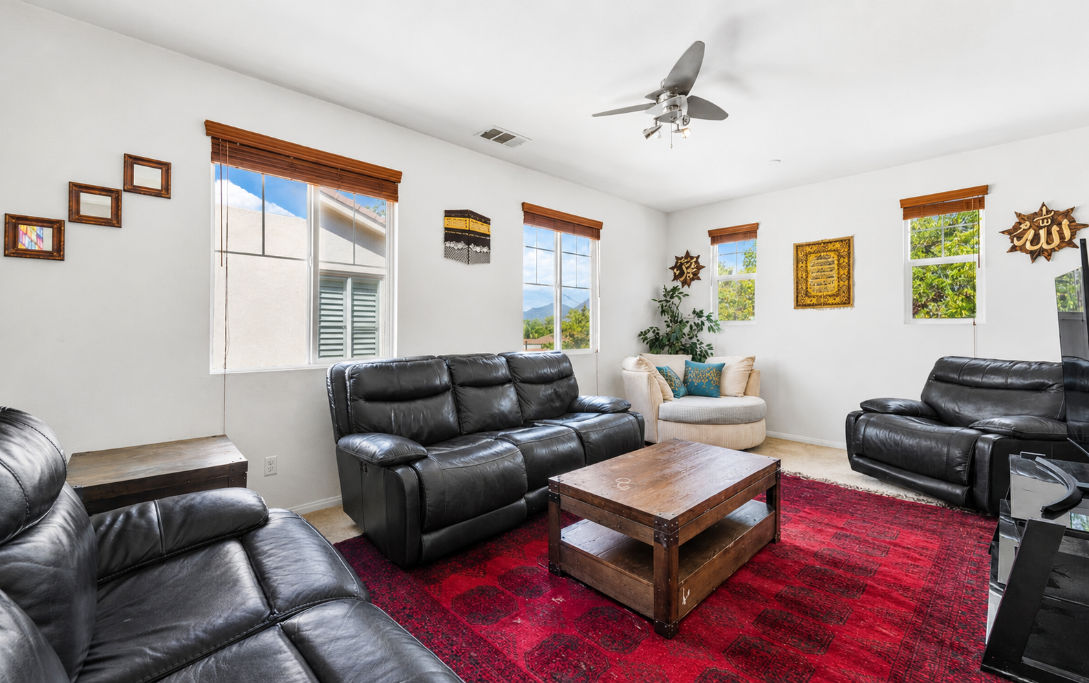 Living room with leather seating, big windows, and a comfortable spot to relax together.