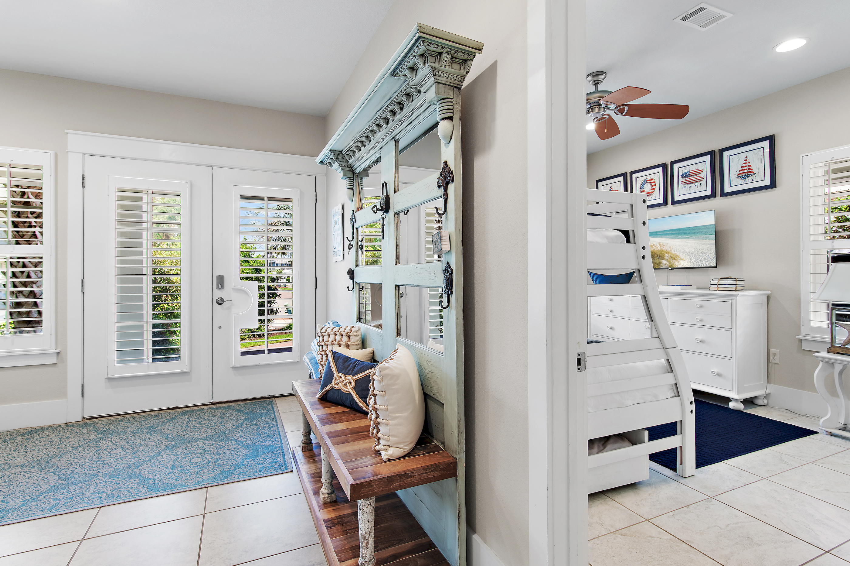 Bright coastal entryway with charming beach inspired décor, a welcoming bench, and beautiful details throughout.