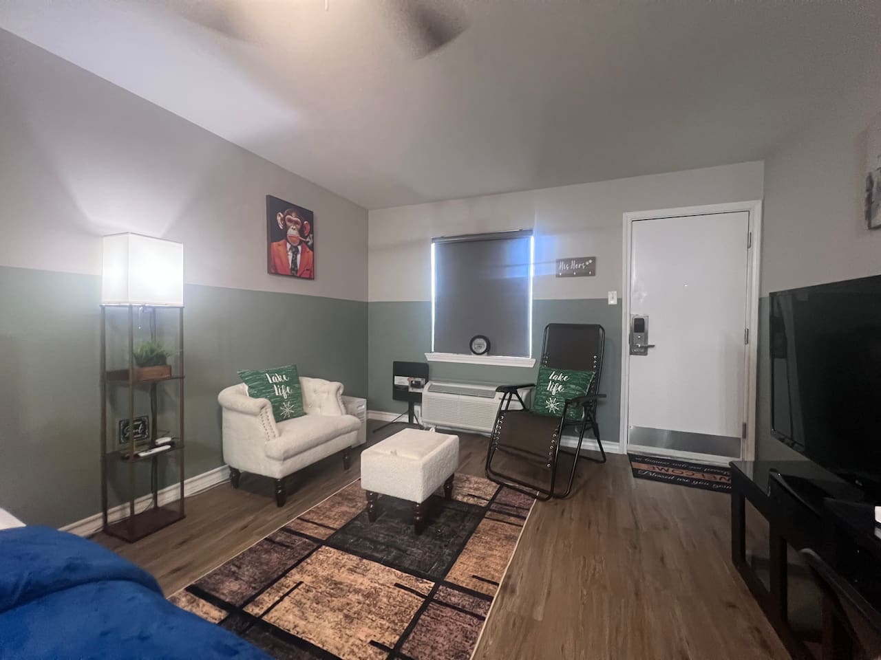 Living space with a TV, accent chairs, and a simple spot to relax or watch a show.
