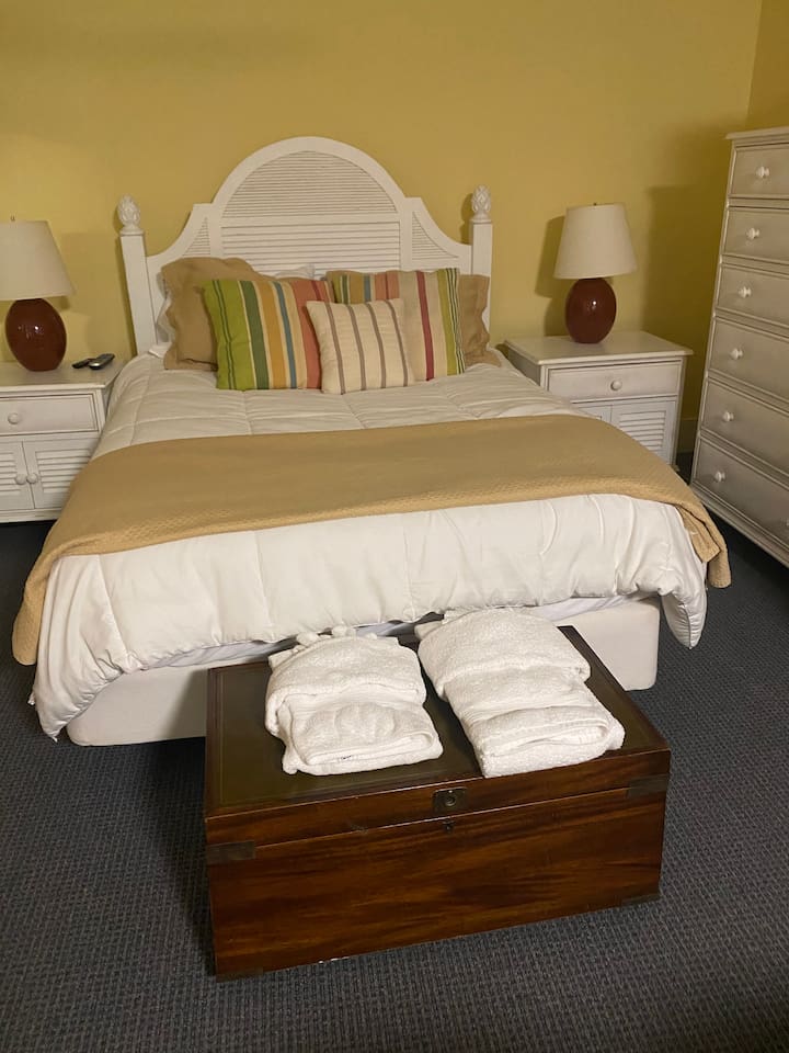 This bedroom is part of a small in-law suite on the lower level. It includes a sitting area, full kitchen, and private full bathroom.