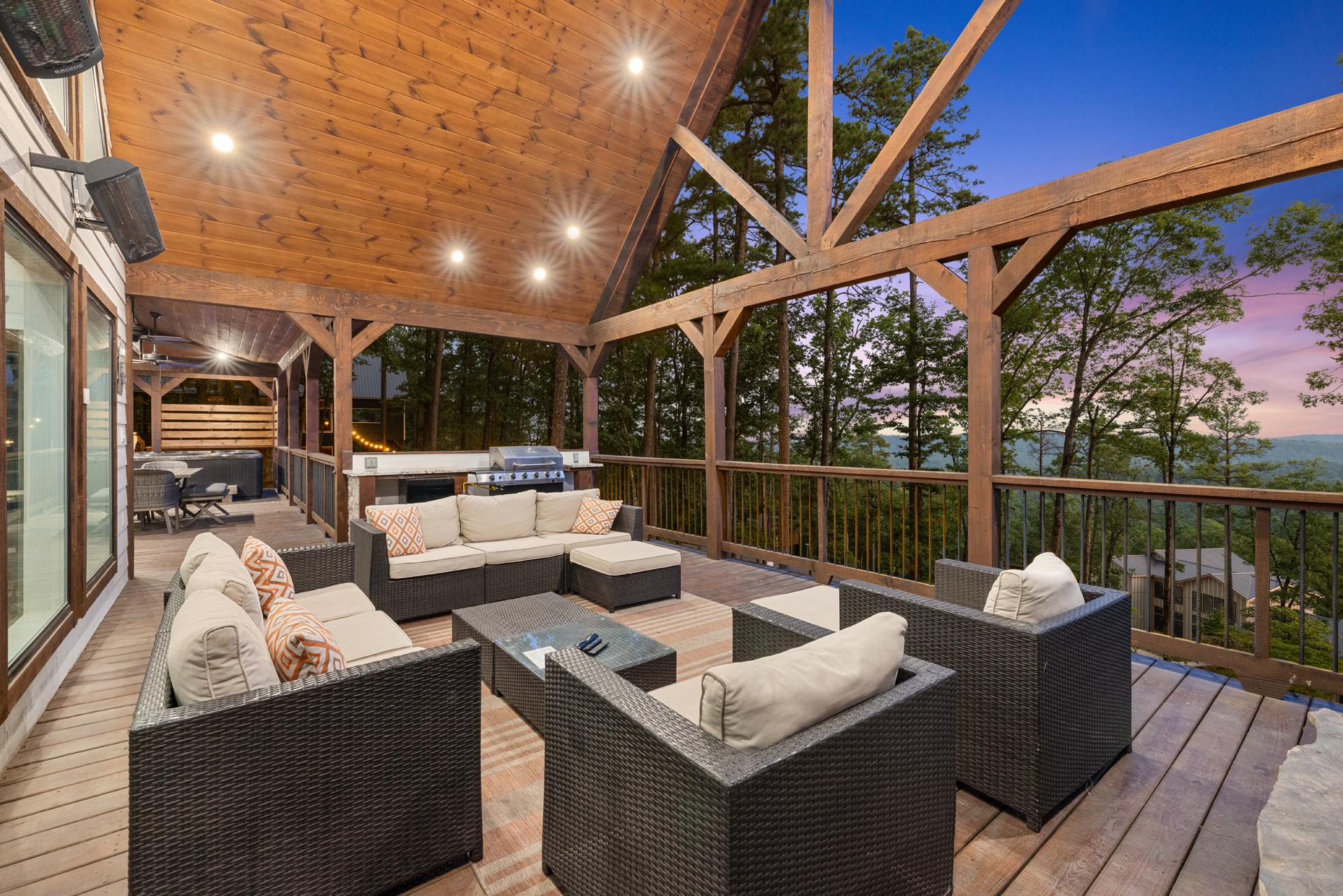 Spacious covered outdoor lounge with cozy seating and breathtaking sunset views