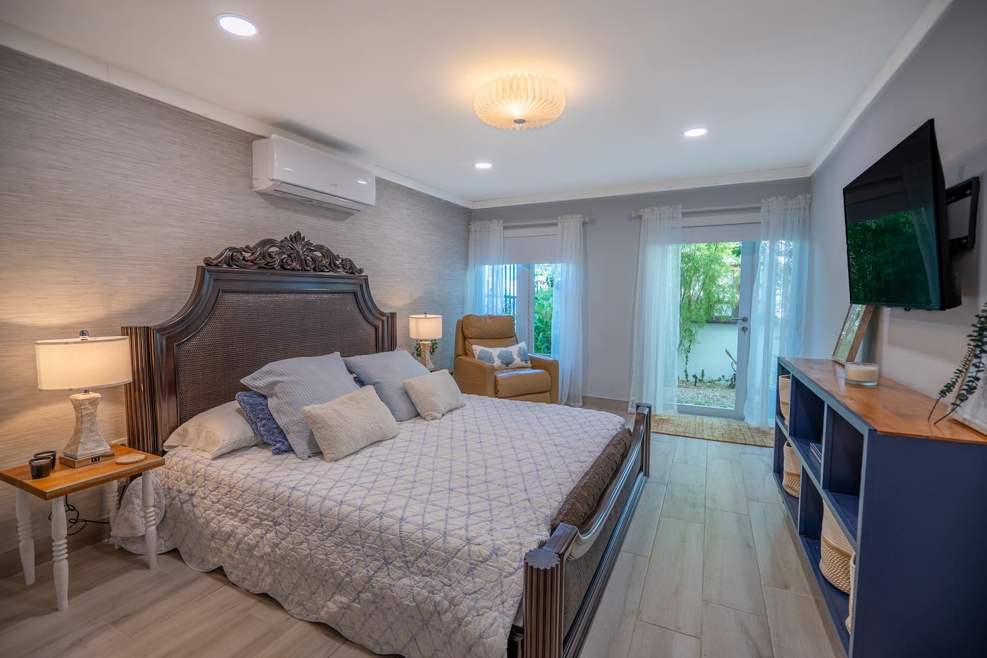 This is the view of the primary King bed. Yes, this mattress is super comfy! The Italian leather recliner is perfecto for reading or resting your eyes(away from your family/group) after a long day at the beach. 