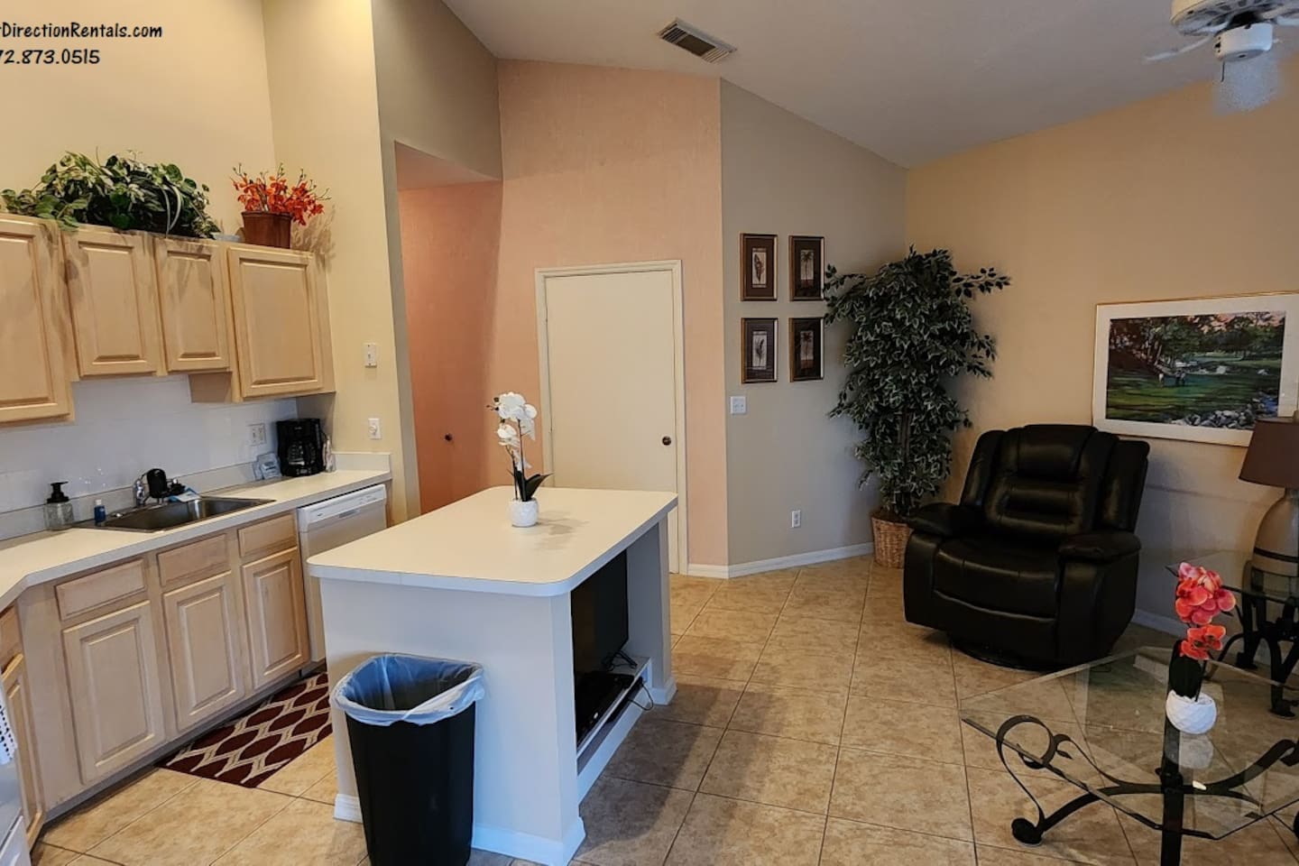 Spacious kitchen and living area featuring vaulted ceilings, plenty of cabinet storage, breakfast bar seating, and comfortable seating.